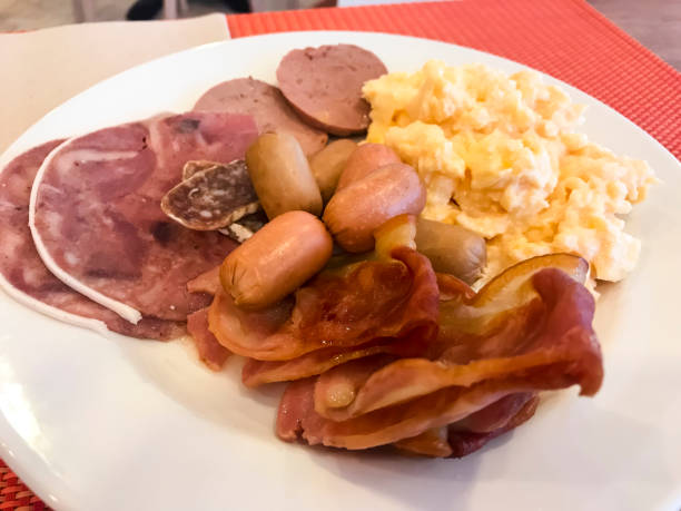 istock Set of dishes on breakfast table. Scrambled eggs, omelette, pate, croissants, champignons, crispy bacon, sausages. 1220737952