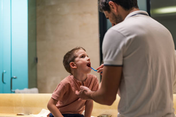 istock Father and son brushing teeth in bathroom 1220739076