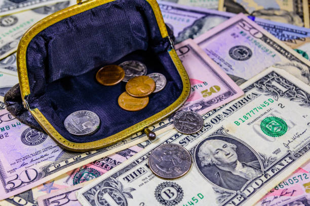 istock Old wallet with american cent coins over the dollar banknotes 1220740197