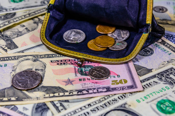 istock Old wallet with american cent coins over the dollar banknotes 1220740198