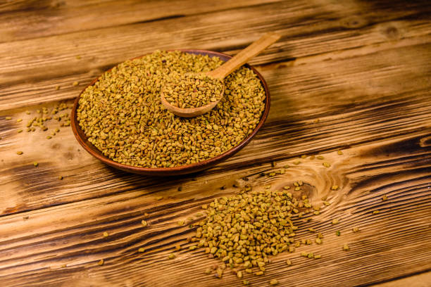 istock Ceramic plate and spoon with fenugreek seeds on wooden table 1220740239