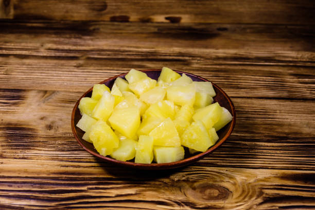 istock Ceramic plate with chopped canned pineapple on wooden table 1220740241