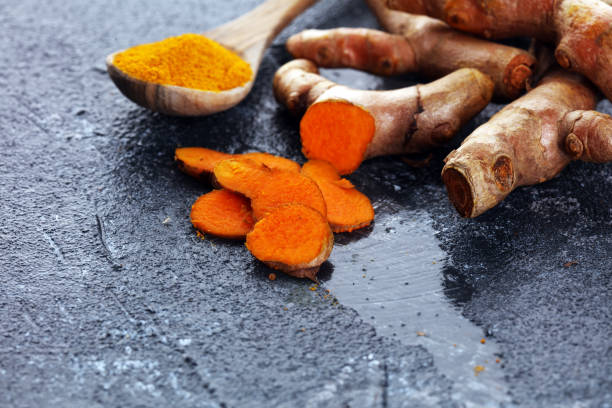istock Turmeric powder and fresh turmeric on table 1220741346