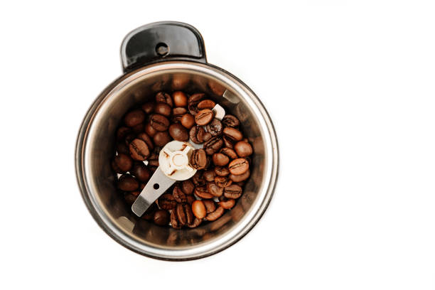 istock Flat lay composition with coffee beans loaded in a coffee grinder on a white background with place for text. 1220743946