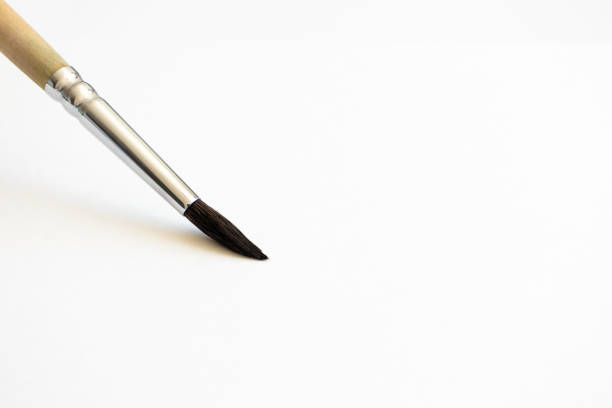 istock Close-up paintbrush on white watercolor paper with selective focus and copy space, horizontal. Hobby and art tool 1220744146