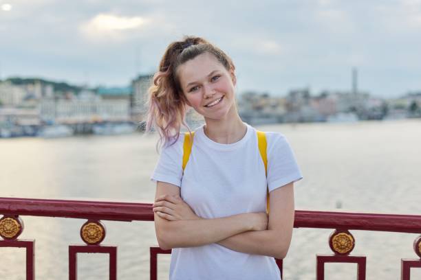 outdoor portrait of smiling teenage girl of 15, 16 years old with folded arms - teenager 14 15 years 13 14 years cheerful imagens e fotografias de stock