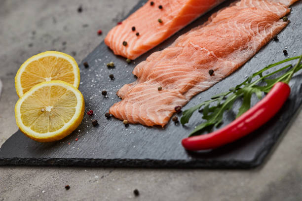 istock Fresh sliced salmon fillet with arugula, avocado and lemon on slate plate. Wild atlantic fish 1220747503