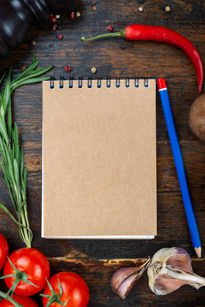 istock vegetables and a paper notebook on a spiral, on a brown wooden background. 1220748947