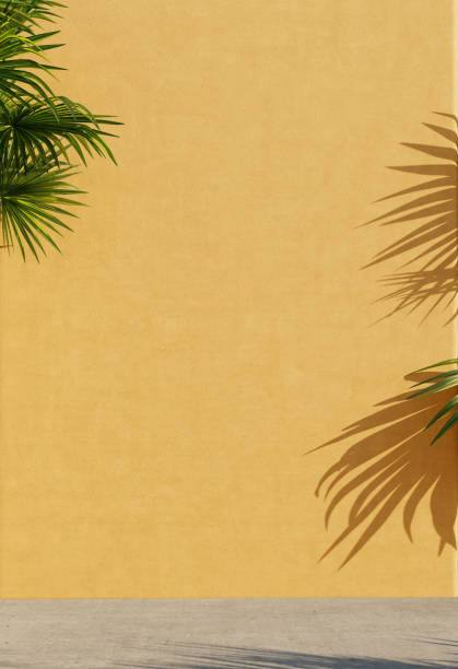 istock Bright yellow painted walls with green tropical leaves, sunlight and shadows. Summer, spring background. 3d rendering. 1220749480