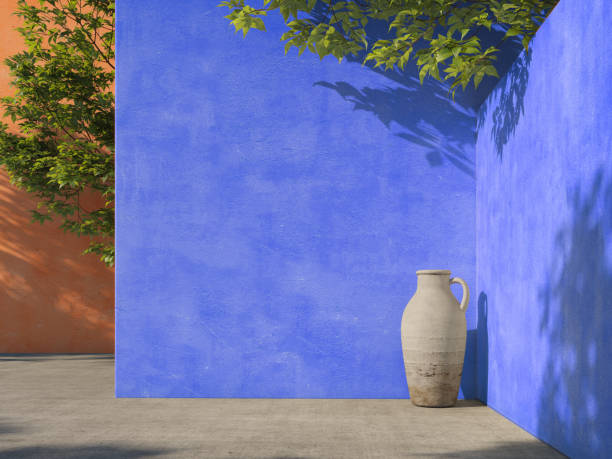 istock Painted blue and orange wall with green tropical leaves, sunlight with shadows. Summer, spring background. 3d rendering. 1220749647