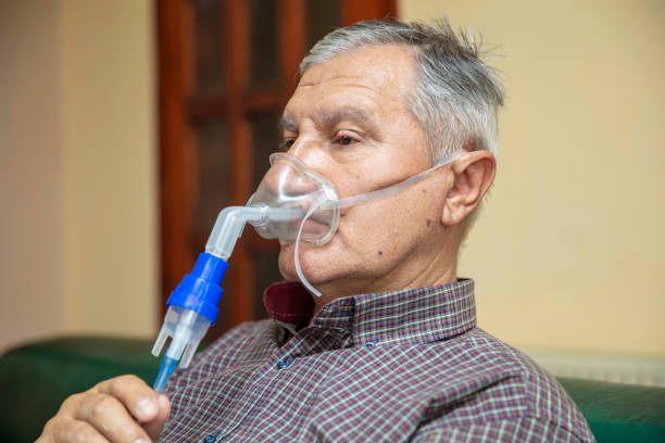 istock Senior man using medical equipment for inhalation with respiratory mask, nebulizer 1220749769