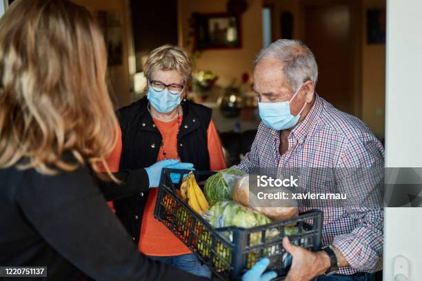 Foto de Neto Entrega Mantimentos Para Avós Durante Pandemia Em Sua Casa e mais fotos de stock de Comida