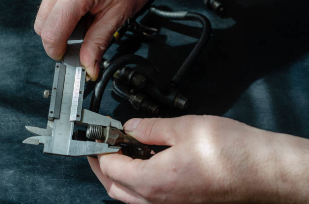 istock Auto mechanic repairs fuel diesel injectors. 1220752661