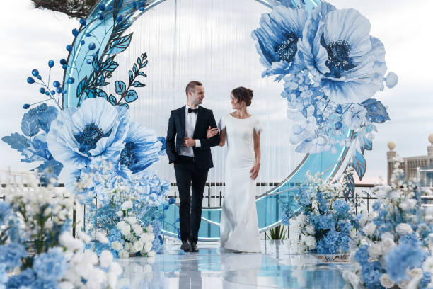 encantadora pareja enamorada en una elegante sala de banquetes al aire libre en el telón de fondo del mar en un día de boda de gala - wedding reception bridesmaid wedding party fotografías e imágenes de stock