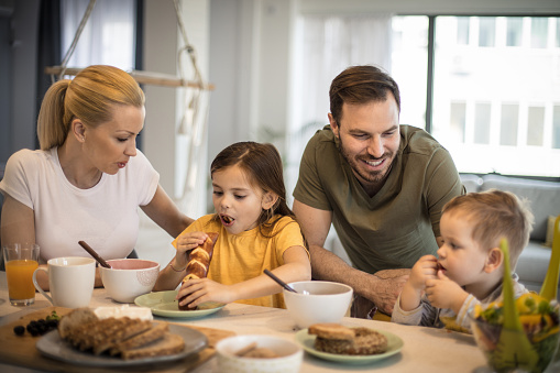 Starting their day with breakfast. Family eating together.