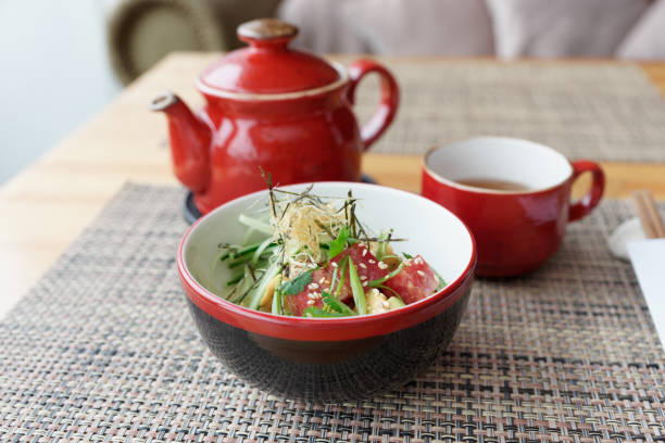 istock Raw tuna poke bowl and tea on restaurant table 1220757301