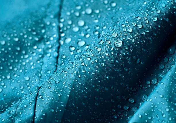 gocce d'acqua sul tessuto. - blue vibrant color close up textile foto e immagini stock