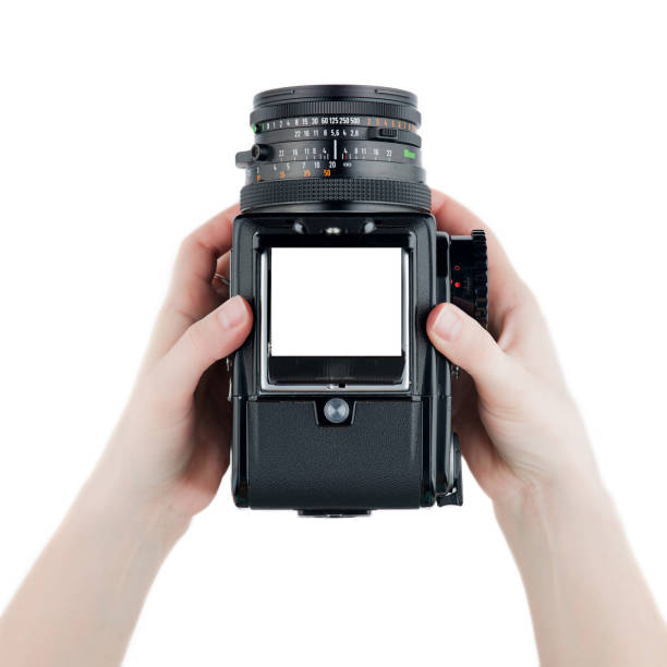 istock Top view Old school film photo camera in hands medium format isolated on white background 1220760185