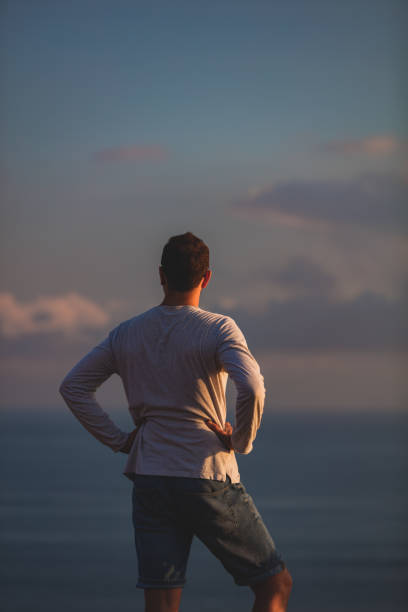 istock Man with nice tropical summertime sunset on the island above the ocean. 1220761400