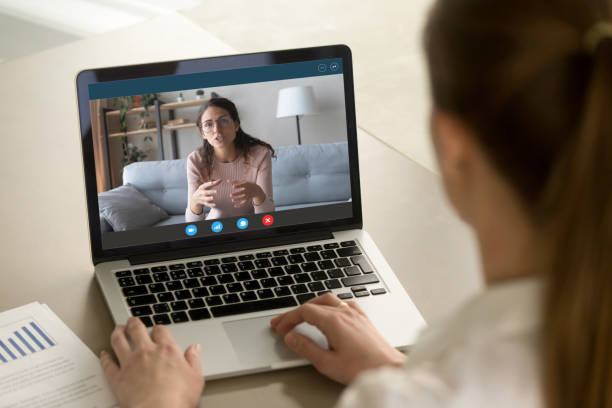 istock Laptop monitor view over female shoulder during distant job interview 1220763548