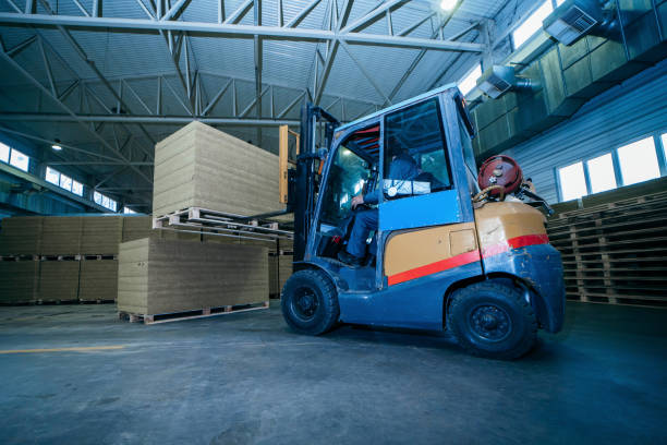 istock Worker driver of a forklift loader at warehouse of sandwich panels 1220764606