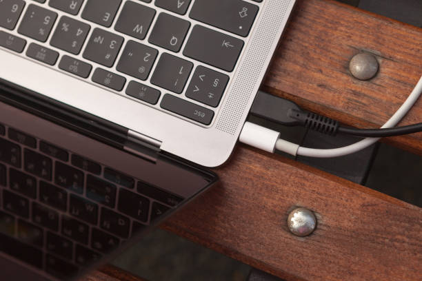 istock Laptop keyboard and two wires close-up on a bench 1220765535