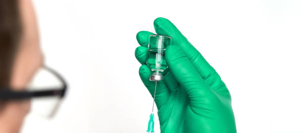 человек в перчатках держит бутылку вакцины со шприцем - doping test стоковые фото и изображения