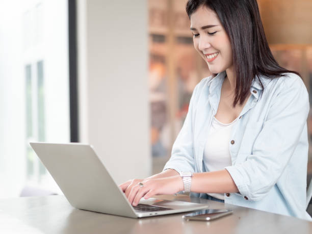 istock Asian woman happy using laptop sitting in room work from home. Technology and communication 1220770388