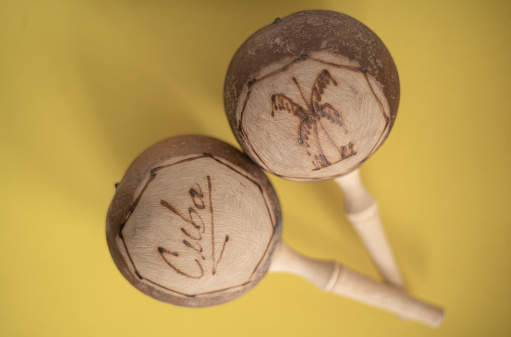 Cuban maracas. Traditional musical instrument isolated close up made of wood natural materials on yellow background