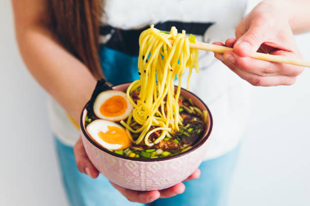 mulher comendo ramen saboroso - sopa de macarrão japonês durante ficar em casa - chopsticks human hand women isolated - fotografias e filmes do acervo