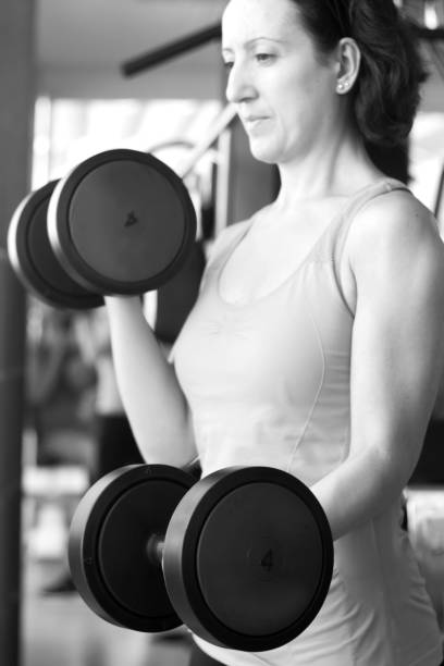 istock Girl doing exercise with 4 kg weights in the gym 1220773091