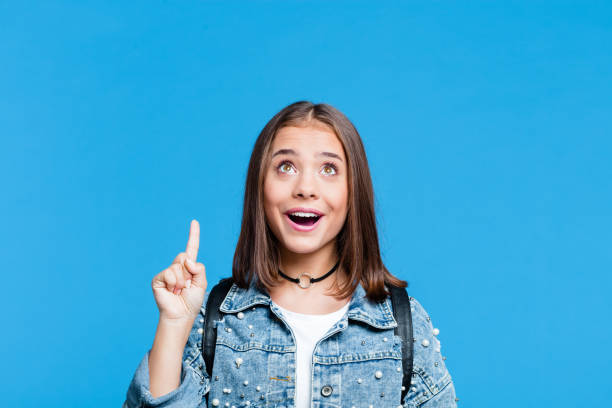 istock Happy teenge girl pointing with finger at copy space 1220774827