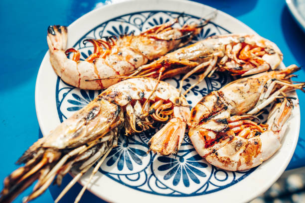 istock Large grilled prawns. Shrimp on a plate with a blue background. 1220775147