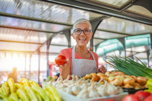 mujer amigable cuidando un vegetal orgánico - bazaar fotografías e imágenes de stock