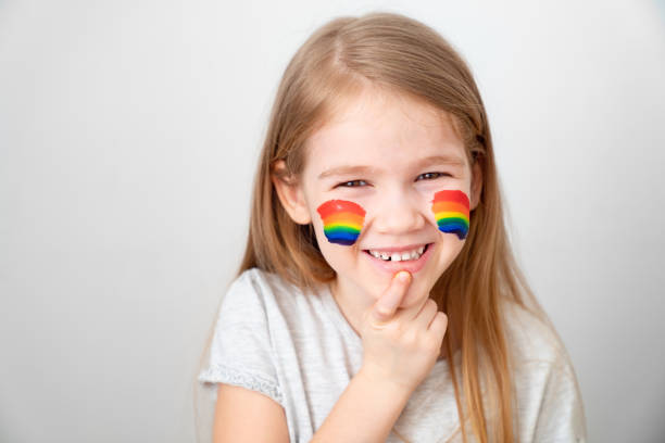 istock child painted cheeks a rainbow. stay home. 1220777162