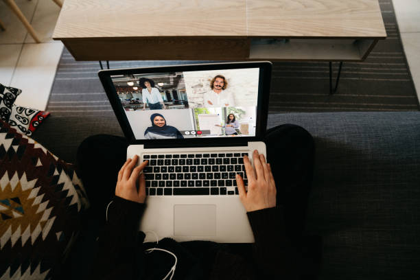 istock Young woman using a laptop on the sofa at home to have a work conference call 1220777932