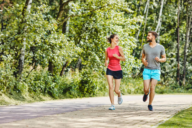 istock Young couple running in the park in summer 1220778648