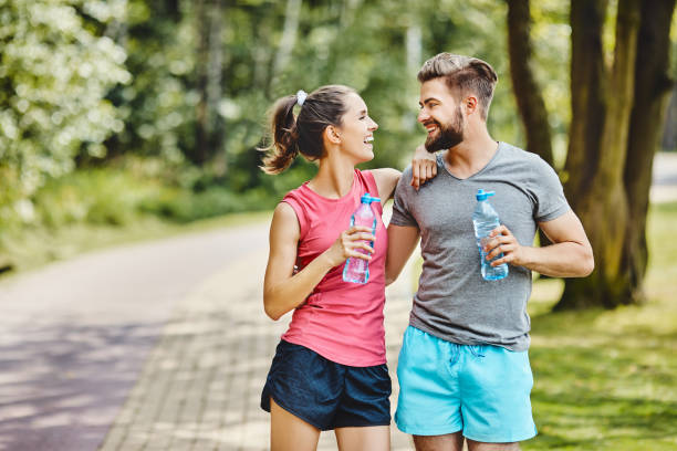 istock Happy couple resting after running at park 1220778768