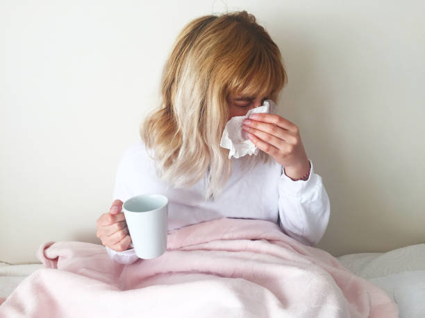 istock sick girl wipes her nose 1220779119