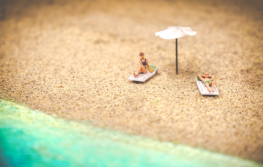 summer background sunbather couple in deserted beach sunbathing with copy space .