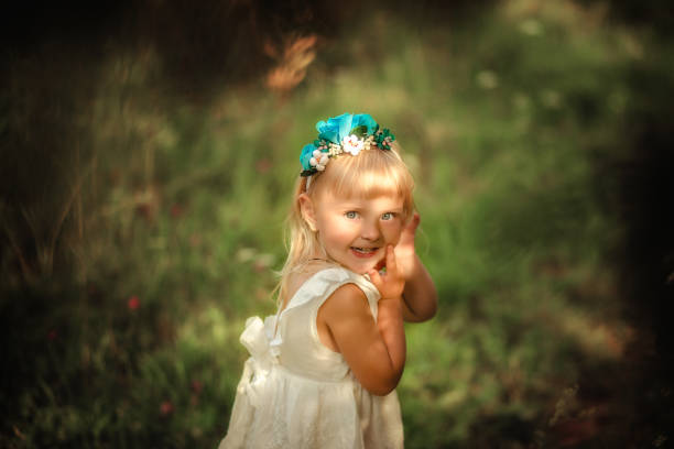 istock Cute baby in white dress smiling 1220781605