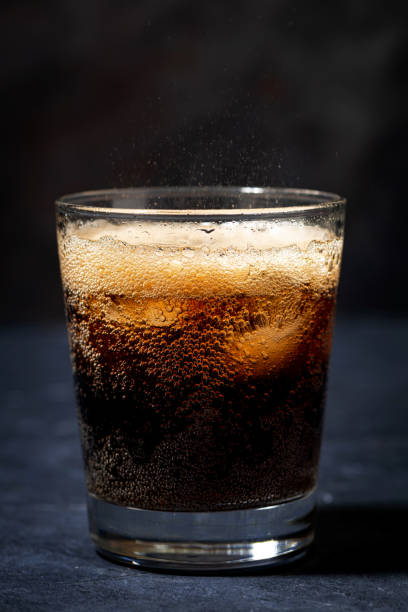 istock Coca Cola with ice in a glass on a dark background 1220781712