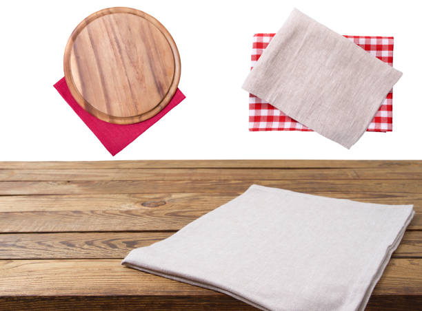 istock Pizza cutting board. Empty tablecloth set and wood table isolated on white background. Selective focus. Place for food. Top view. Mockup and template copy space. 1220781747