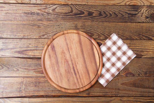 istock Brown old vintage wooden table with framed checkered tablecloth and pizza cutting board.Thanksgiving day and Cristmas table concept. Top view and copy space. Selective focus 1220781976
