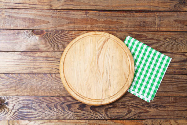 istock Brown old vintage wooden table with framed checkered tablecloth and pizza cutting board.Thanksgiving day and Cristmas table concept. Top view and copy space. Selective focus 1220781981