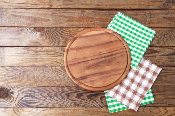 istock Brown old vintage wooden table with framed checkered tablecloth and pizza cutting board.Thanksgiving day and Cristmas table concept. Top view and copy space. Selective focus 1220781988