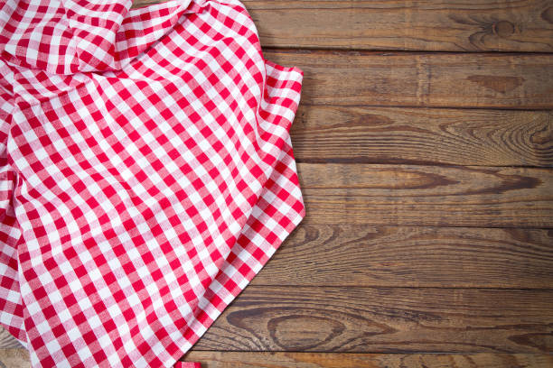 istock Brown old vintage wooden table with framed red checkered tablecloth. Thanksgiving day and Cristmas table concept. Top view and copy space. Selective focus 1220782013