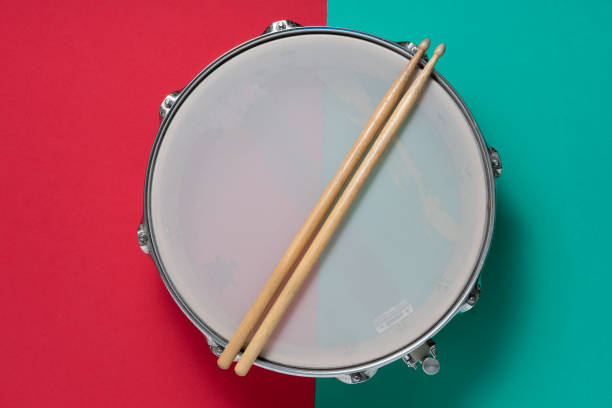 istock Drum and drum stick on red and green table background, top view, music concept 1220790733