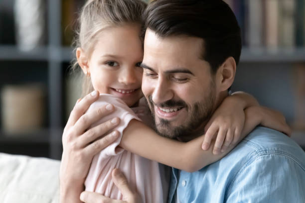 istock Close up image little daughter embracing young daddy 1220790958