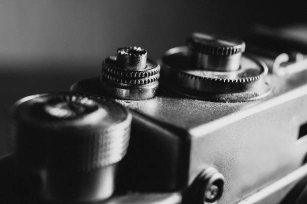 istock shutter button of an old camera, black and white photo with noise 1220791148